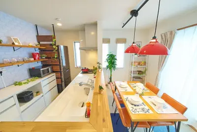 a kitchen and dining room with a table and red lights at Sumida A Cozy Entire House Sleeps 8 Near Station Tokyo Skytree Asakusa in Tokyo