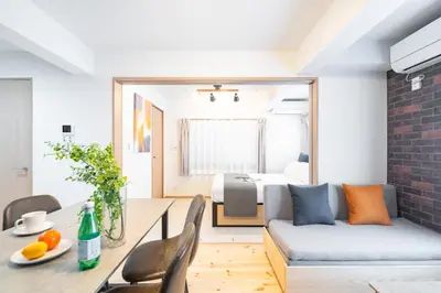 a living room with a dining table and a bedroom at \u30f4\u30a3\u30f3\u30c6\u30fc\u30b8CiTY\u4e21\u56fd in Tokyo