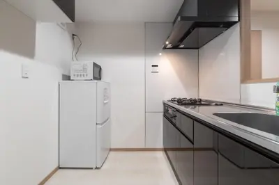 a kitchen with a white refrigerator and a sink at \u30f4\u30a3\u30f3\u30c6\u30fc\u30b8CiTY\u4e21\u56fd in Tokyo