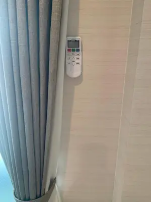 a remote control sitting on the side of a curtain at Li Tokyo otta in Tokyo