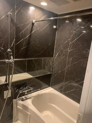 a bathroom with a tub and a black tiled wall at Li Tokyo otta in Tokyo