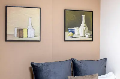 two paintings of vases on a wall with a couch at Livecore -Apartment hotel- in Tokyo