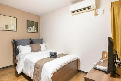 a bedroom with a bed and a flat screen tv at Livecore -Apartment hotel- in Tokyo