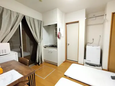 a living room with a table and a kitchen at Senju 101, Cozy Tokyo Studio in Tokyo