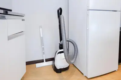 a vacuum cleaner hanging from the side of a refrigerator at TS Yoyogi by Tranova in Tokyo