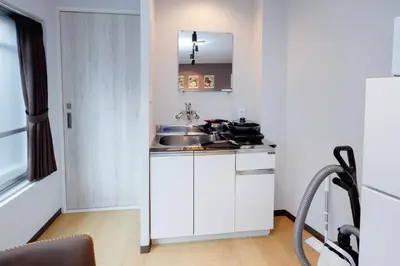 a small white kitchen with a sink and a counter at TS Yoyogi by Tranova in Tokyo