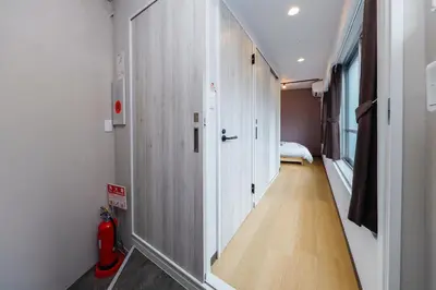 a hallway with white walls and a room with a bed at TS Yoyogi by Tranova in Tokyo