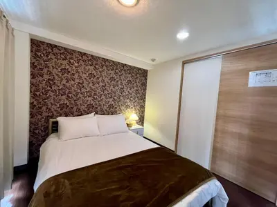 a bedroom with a large bed and a wall at Imperial Tateishi in Tokyo