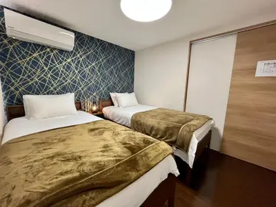 a hotel room with two beds and a fan at Imperial Tateishi in Tokyo