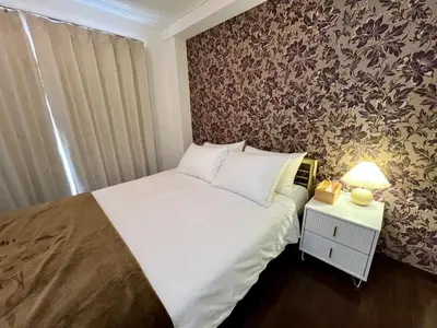 a bedroom with a bed and a wall with floral wallpaper at Imperial Tateishi in Tokyo