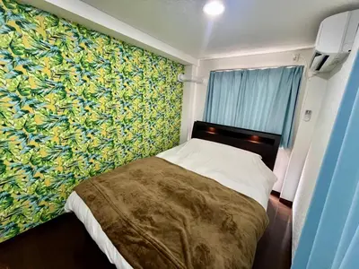a bedroom with a bed with a colorful wall at Imperial Tateishi in Tokyo
