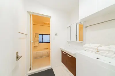 a white bathroom with a sink and a mirror at Nine Lane Nippori in Tokyo