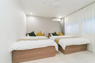 a bedroom with two beds and a window at Nine Lane Nippori in Tokyo