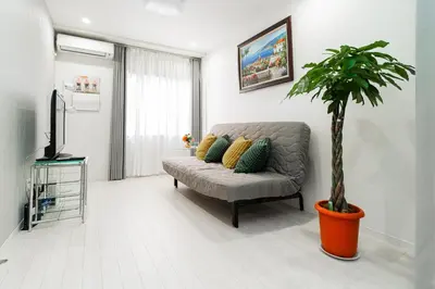 a living room with a couch and a potted plant at Nine Lane Nippori in Tokyo
