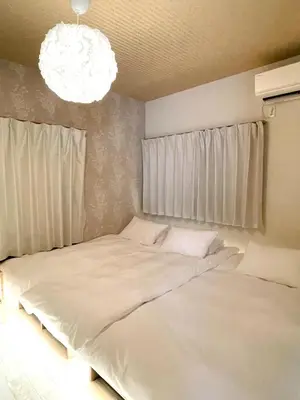 a bedroom with a large white bed with a chandelier at \u30df\u30ce\u30eb\u30d0\u91d1\u753a in Tokyo