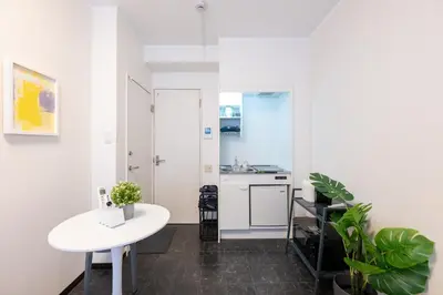 a kitchen with a white table and a white counter at Tune Inn Residence Nihonbashi in Tokyo