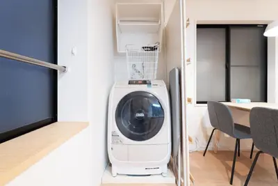 a washing machine in a room with a table and chairs at SATELLITE HOTEL Roppongi 2nd \u30b5\u30c6\u30e9\u30a4\u30c8\u30db\u30c6\u30eb\u516d\u672c\u67282nd in Tokyo