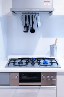 a stove top oven in a white kitchen at SATELLITE HOTEL Roppongi 2nd \u30b5\u30c6\u30e9\u30a4\u30c8\u30db\u30c6\u30eb\u516d\u672c\u67282nd in Tokyo