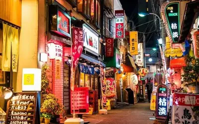 a street in an asian city at night with signs at Akabane Nishi Masuda House in Tokyo