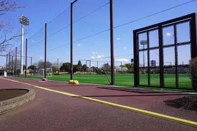a batting cage with a large glass door on a field at Akabane Nishi Masuda House in Tokyo