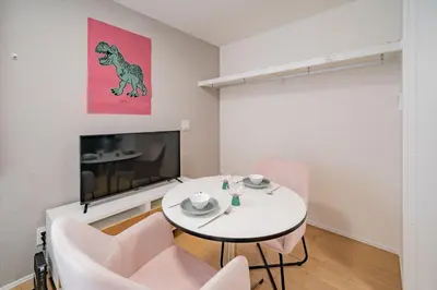 a living room with a white table and a tv at PRIME Shinjuku by Tranova in Tokyo