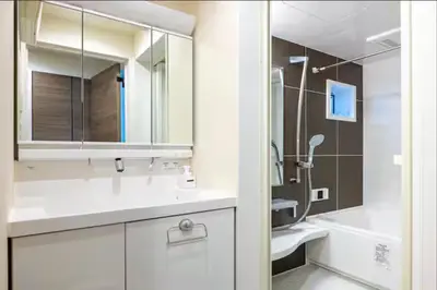 a white bathroom with a sink and a mirror at \u6e0b\u8c37\u672c\u753a4\u4e01\u76ee in Tokyo