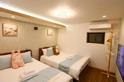 a hotel room with two beds and a tv at 101 Convenient Ueno Lucky Yado in Tokyo
