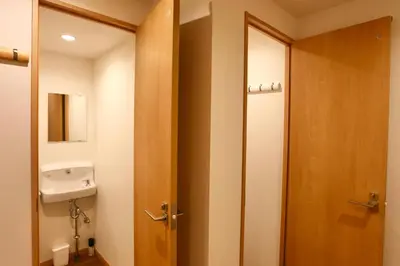 a bathroom with a wooden door and a sink at 101 Convenient Ueno Lucky Yado in Tokyo