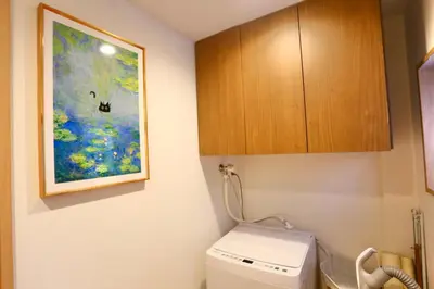 a bathroom with a toilet and a painting on the wall at 101 Convenient Ueno Lucky Yado in Tokyo