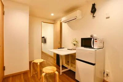 a small kitchen with a table and a refrigerator at 101 Convenient Ueno Lucky Yado in Tokyo