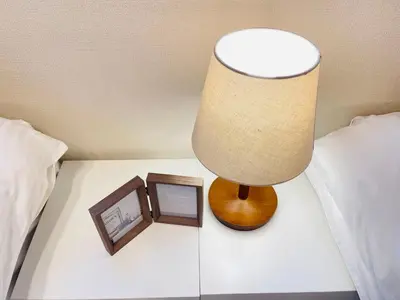 a lamp on a table next to a bed at New open! Ikebukuro smart home \u6728\u6728\u65b0\u9928 in Tokyo