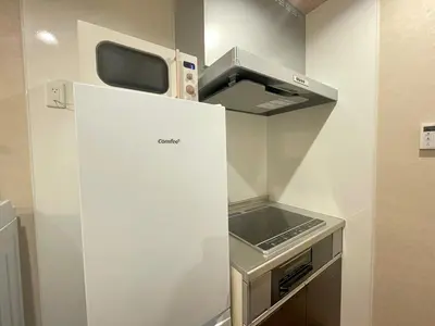 a small kitchen with a microwave on top of a refrigerator at OPEN SALE! Stylish Stay near AKIHABARA! May2025 Open! \u79cb\u8449\u539f CORE HOTEL in Tokyo