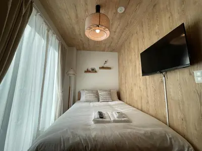 a bedroom with a bed with a television on the wall at OPEN SALE! Stylish Stay near AKIHABARA! May2025 Open! \u79cb\u8449\u539f CORE HOTEL in Tokyo