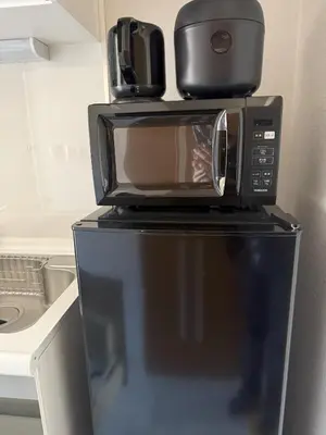 a microwave sitting on top of a refrigerator at Walk to JR Shinjuku - Grand Écru II 403 - Balcony & Kitchen in Tokyo