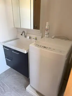 a bathroom with a sink and a washing machine at Walk to JR Shinjuku - Grand Écru II 403 - Balcony & Kitchen in Tokyo