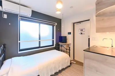 a bedroom with a bed and a window and a sink at HJ PLACE Takanawa by Tranova in Tokyo