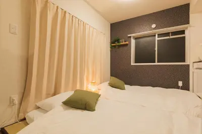 two white beds in a room with a window at \u6771\u4eac\u90fd\u5fc315\u5206 \u6210\u7530\u7a7a\u6e2f1\u6642\u9593 \u99c5\u304b\u3089\u5f92\u6b6910\u5206\u306e\u65b0\u88c5\u30de\u30f3\u30b7\u30e7\u30f3 in Tokyo