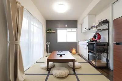 a living room with a table and a kitchen at \u6771\u4eac\u90fd\u5fc315\u5206 \u6210\u7530\u7a7a\u6e2f1\u6642\u9593 \u99c5\u304b\u3089\u5f92\u6b6910\u5206\u306e\u65b0\u88c5\u30de\u30f3\u30b7\u30e7\u30f3 in Tokyo