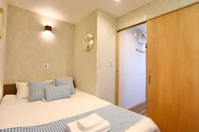 a bedroom with a bed with blue and white pillows at 201 Modern Ueno House Lucky Yado in Tokyo