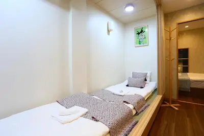 a bedroom with two beds with towels on them at 201 Modern Ueno House Lucky Yado in Tokyo