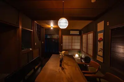 a room with a wooden table with chairs and a lamp at 6-minute walk to Tokyo Skytree Up to 6 people 68 sqm fully renovated direct access to Asakusa, Shibuya, Narita Airport, and Haneda Airport in Tokyo