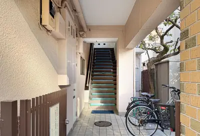 a hallway with stairs and a bike parked next to a building at \u304b\u3064\u3089306 in Tokyo