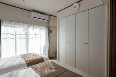 a bedroom with a bed and a clock on the wall at \u304b\u3064\u3089306 in Tokyo