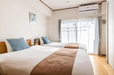 two beds in a room with a window at \u304b\u3064\u3089306 in Tokyo