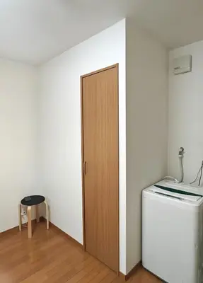 a room with a wooden door next to a refrigerator at Senju 102, Restful Tokyo Studio in Tokyo