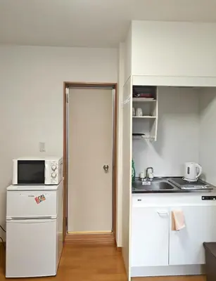 a small white kitchen with a sink and a microwave at Senju 102, Restful Tokyo Studio in Tokyo