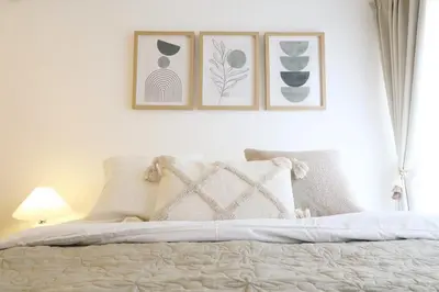 a bedroom with a bed with four pictures on the wall at \u30b9\u30ab\u30a4\u30d4\u30a2\u9ad8\u7802 206 in Tokyo