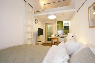 a bedroom with a large bed and a kitchen at \u30b9\u30ab\u30a4\u30d4\u30a2\u9ad8\u7802 206 in Tokyo