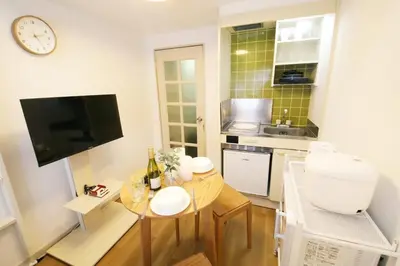 a small kitchen with a table and a clock on the wall at \u30b9\u30ab\u30a4\u30d4\u30a2\u9ad8\u7802 206 in Tokyo