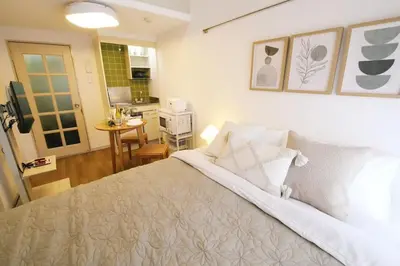 a bedroom with a bed and a kitchen at \u30b9\u30ab\u30a4\u30d4\u30a2\u9ad8\u7802 206 in Tokyo